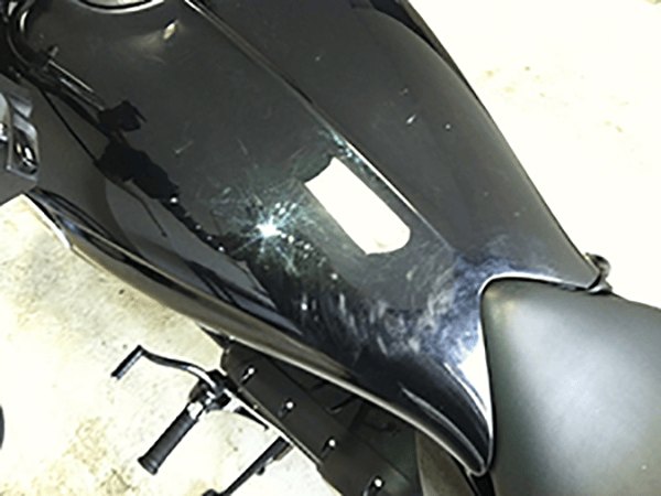 Motorcycle tank before detailing, dull with swirl marks